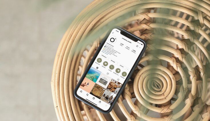 Phone on table with Compass Studio's Instagram profile on the screen